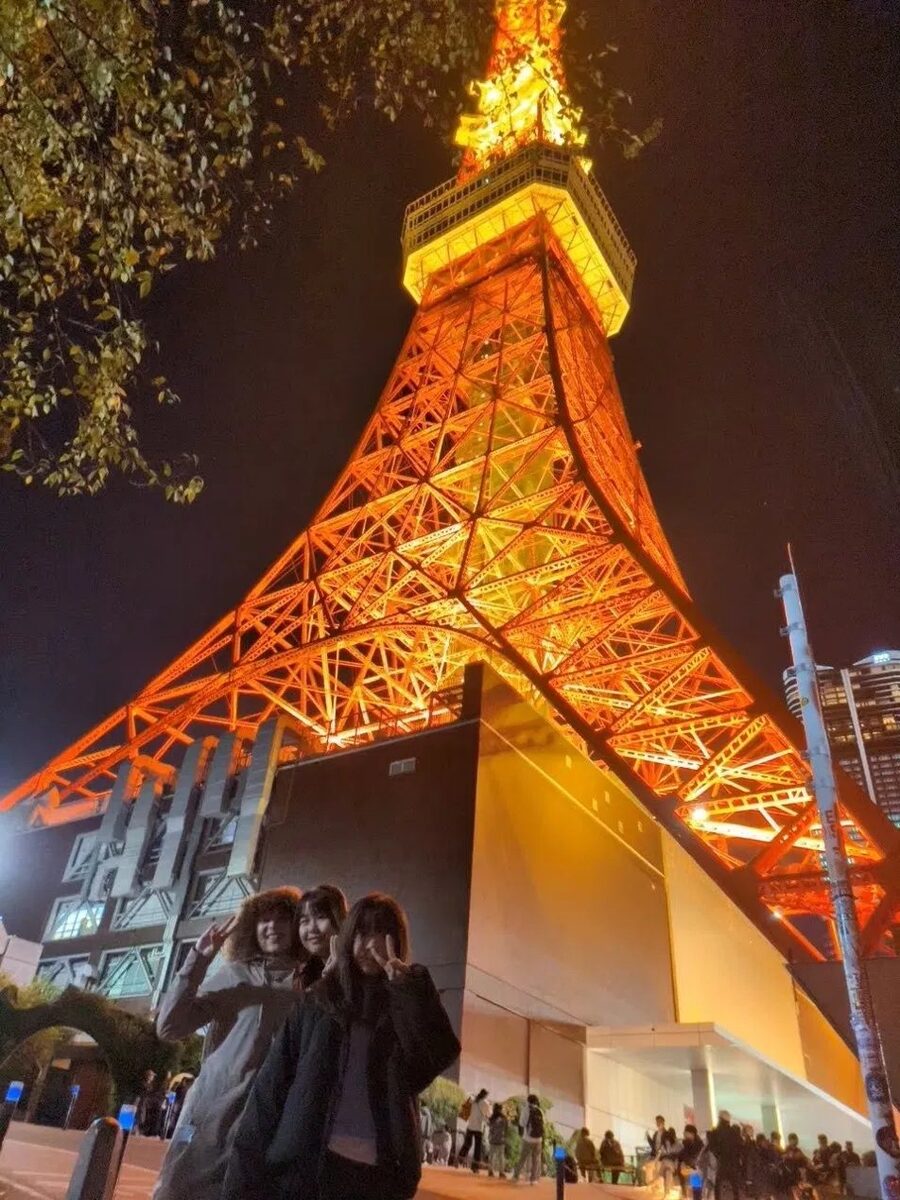 Students at the base of Tokyo Tower lit up at night