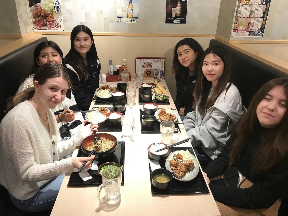 Students sharing a Japanese dinner around the table