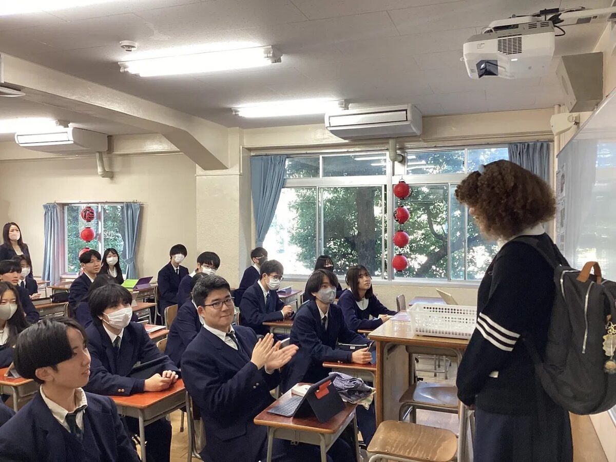 An EduAbroad student speaking with students in a Japanese classroom